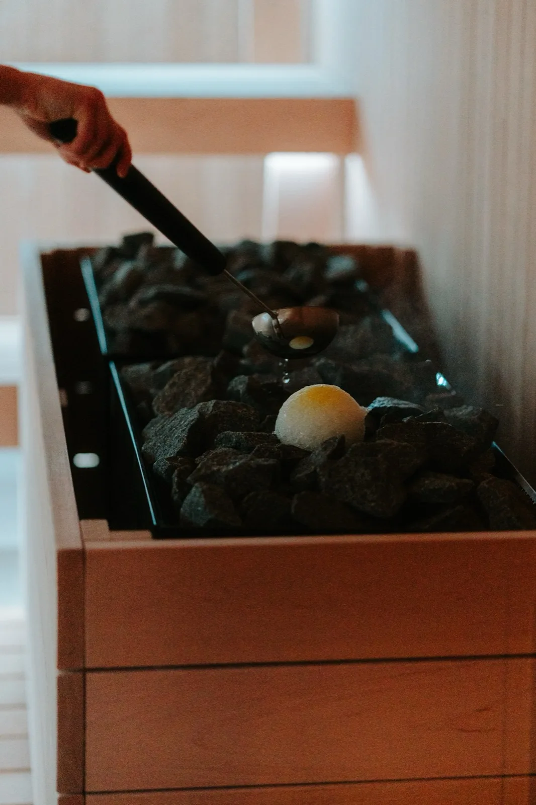 A sauna master working beside the warm stove.
